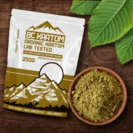 Yellow BC Kratom bag laying on a wooden table beside a bowl of Yellow Vietnam Kratom Powder