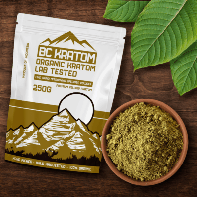 Yellow BC Kratom bag laying on a wooden table beside a bowl of Yellow Vietnam Kratom Powder