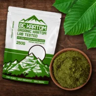 Green BC Kratom Bag laying on a wooden table next to a bowl of Green Sumatra Kratom Powder