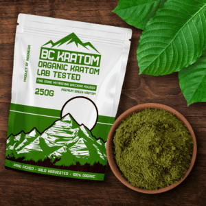 Green BC Kratom Bag laying on a wooden table next to a bowl of Green Sumatra Kratom Powder