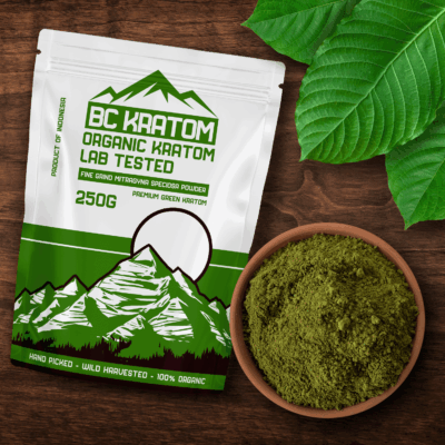 Green BC Kratom Bag laying on a wooden table next to a bowl of Green Sumatra Kratom Powder