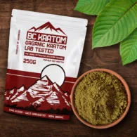 Red BC Kratom Bag laying in a wooden table next to a bowl of Red Sumatra Kratom Powder