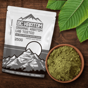 White BC Kratom bag laying on a wooden table next to a bowl of White Indonesian Kratom powder