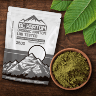 White BC Kratom bag laying on a wooden table next to a bowl of White Jongkong Kratom Powder