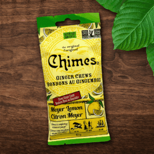 Original Meyer Lemon Chimes small candy pouch laid down on a wooden table with leaves.