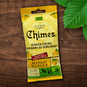 Original Mango Chimes small candy pouch laid down on a wooden table with leaves.